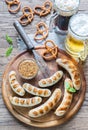 Grilled sausages with pretzels and mugs of beer Royalty Free Stock Photo