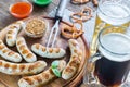 Grilled sausages with pretzels and mugs of beer Royalty Free Stock Photo