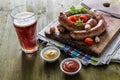 Grilled sausages served on wood board Royalty Free Stock Photo