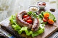 Grilled sausages served on wood board Royalty Free Stock Photo