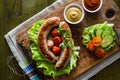 Grilled sausages served on wood board Royalty Free Stock Photo