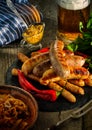 Grilled sausages and stewed cabbage with a mug of beer on a wood Royalty Free Stock Photo