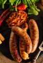 Grilled sausages and stewed cabbage with a mug of beer on a wood Royalty Free Stock Photo