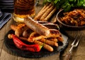 Grilled sausages and stewed cabbage with a mug of beer on a wood Royalty Free Stock Photo