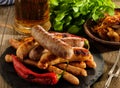 Grilled sausages and stewed cabbage with a mug of beer on a wood Royalty Free Stock Photo