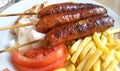 Grilled sausages on the stick with french fries