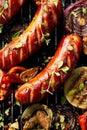 Grilled sausages and vegetables with addition spices and fresh herbs on a grill Royalty Free Stock Photo