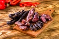 Grilled sausages with vegetables close up on an old table Royalty Free Stock Photo