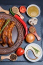 Grilled sausages, vegetables, hot peppers and various spices and ingredients on a black background Royalty Free Stock Photo