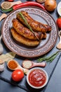 Grilled sausages, vegetables, hot peppers and various spices and ingredients on a black background Royalty Free Stock Photo