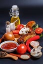 Grilled sausages, vegetables, hot peppers and various spices and ingredients on a black background Royalty Free Stock Photo