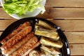 Grilled sausages with vegetables on wooden table