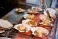 Grilled scallop with the seashell on stove in Kuromon Ichiba Mar