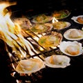 Grilled scallops topped with butter, garlic and parsley on flami