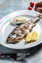 Grilled sea bass, Grilled Fresh sea bass. Mediterranean fish, baked with herbs and lemon. vertical image. top view. place for text Royalty Free Stock Photo