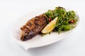 Grilled sea bream fish, lemon, arugula on white Royalty Free Stock Photo