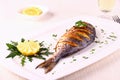 Grilled sea bream fish, lemon, arugula on white plate Royalty Free Stock Photo