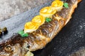 Grilled sea fish with lemon on stone slate background close up. Healthy food. Royalty Free Stock Photo