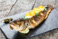 Grilled sea fish with lemon on stone slate background close up. Healthy food. Top view. Royalty Free Stock Photo