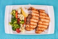 Grilled seafood. Salmon fish steak with greens, broccoli, cauliflower, carrots, cucumber, lemon and chili. Royalty Free Stock Photo