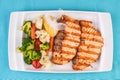 Grilled seafood. Salmon fish steak with greens, broccoli, cauliflower, carrots, cucumber, lemon and chili. Royalty Free Stock Photo