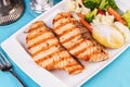 Grilled seafood. Salmon fish steak with greens, broccoli, cauliflower, carrots, cucumber, lemon and chili. Royalty Free Stock Photo