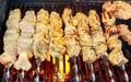 Grilled shish kebab on metal skewer. Chef hands cooking roasted meat barbecue with lots of smoke. Royalty Free Stock Photo