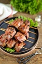 Grilled Shish kebab from a turkey liver in bacon on wooden skewers.