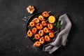 Grilled shrimp with garlic and lemon on black background