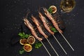 Grilled shrimp skewers. Seafood, shellfish. Shrimps Prawns skewers with herbs, garlic and lemon on black stone Royalty Free Stock Photo