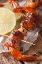 Grilled shrimp wrapped in bacon with spices and lime close up. v