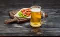 Grilled shrimps on a board and beer mug. Dark wooden table. Royalty Free Stock Photo