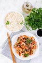 Grilled shrimps and boiled rice. King prawn tails in orange-garlic sauce with parsley.