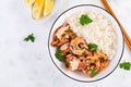 Grilled shrimps and boiled rice. King prawn tails in orange-garlic sauce with parsley.