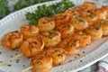 Grilled shrimps elegantly served on a pristine white plate for a delightful dining experience