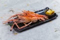 Grilled shrimps Giant Tiger Pawn with salt served with sliced lemon in black stone plate on washi Japanese paper