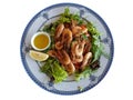 Grilled shrimps on a green salad. Dish in a restaurant on a beautiful plate with a blue ornament and seashells not a white Royalty Free Stock Photo
