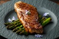 Grilled Sirloin beef steak on fried asparagus served on black slate plate with rosemary flowers Royalty Free Stock Photo
