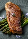 Grilled Sirloin beef steak on fried asparagus served on black slate plate with rosemary flowers Royalty Free Stock Photo