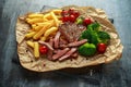 Grilled sirloin steak with potato fries, broccoli and cherry tomatoes on crumpled paper Royalty Free Stock Photo