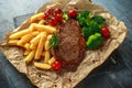 Grilled sirloin steak with potato fries, broccoli and cherry tomatoes on crumpled paper Royalty Free Stock Photo