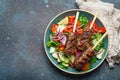 Grilled skewer meat beef kebabs on sticks served with fresh vegetables salad on plate on rustic concrete background from Royalty Free Stock Photo