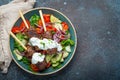 Grilled skewer meat beef kebabs on sticks served with fresh vegetables salad on plate on rustic concrete background from Royalty Free Stock Photo