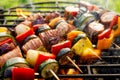 Grilled skewers of meat, sausages and various vegetables on a grill plate, outdoors, top view. Royalty Free Stock Photo