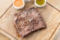 Grilled Skirt Steak with Pickled cabbage and two sauces. Serving on a wooden Board. Barbecue restaurant menu, a series Royalty Free Stock Photo