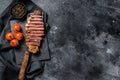 Grilled sliced sirloin steak on a meat cleaver. Black background. Top view. Copy space
