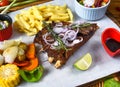 Grilled smoked pork ribs with french fries and soy sauce and salad on wooden board Royalty Free Stock Photo