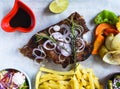 Grilled smoked pork ribs with french fries and soy sauce and salad on wooden board Royalty Free Stock Photo