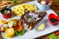 Grilled smoked pork ribs with french fries and soy sauce and salad on wooden board Royalty Free Stock Photo