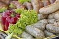 Grilled smoked sausages and meatballs outdoors. Meat baked on the grill bbq. Meat delicacies. Sausages homemade sausages on the Royalty Free Stock Photo